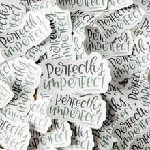 Load image into Gallery viewer, A pile of stickers with text "perfectly imperfect" in two different colors. "Perfectly" is gray, and "imperfect" is green. The background color is white.