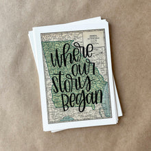 Load image into Gallery viewer, A stack of maps with a vintage design of the state of Georgia with black lettered text "where our story began" over the print. The maps are lying on a large piece of brown paper.