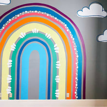 Load image into Gallery viewer, Final rainbow mural in A's bedroom. The rainbow is eggplant purple, navy blue salmon pink, orange, butter yellow, kelly green, navy, and cyan blue with white circle accents and flourishes. There are white clouds surrounding the rainbow with off centered navy outlines.