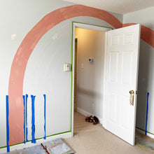 Load image into Gallery viewer, The first rainbow strip is up on B's rainbow mural. It is a thick stripe, possible 4" wide, and is a salmon pink.
