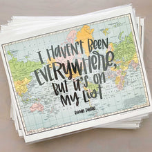 Load image into Gallery viewer, Stack of horizontal multicolored vintage style maps of the world with hand lettered text that says "I haven't been everywhere, but it's on my list" in black lettering