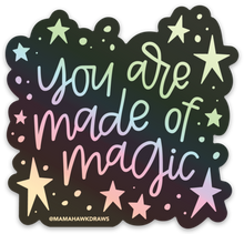 Load image into Gallery viewer, Black sticker with colorful hologram hand lettering that reads "you are made of magic" with stars.