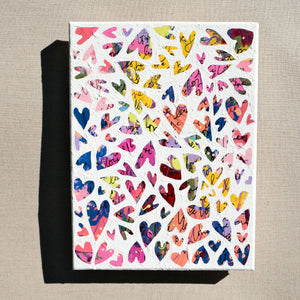 A colorful abstract painting painted over with white to show heart designs in the negative colored space.