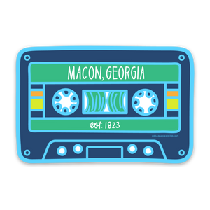 A stylized cassette tape design with colors light blue, navy blue, green, yellow, orange, and white. Text "Macon, Georgia" and "est. 1823" are printed in white on the design.