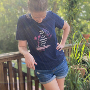 Erin, aka Mama Hawk Draws, wears the navy blue t-shirt she designed for A Girl Like Me's clothing line. The quote on the tee says "today I plan to crush misogyny, destroy sexism, and sparkle."