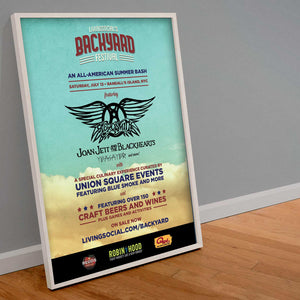 A sign rests on a gray wall on wood flooring. The sign is titled "living social's Backyard Festial" with information regarding the festival printed on a sky background with clouds at the bottom
