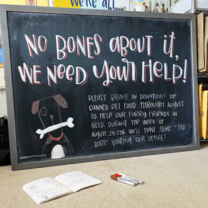 Larger Than Life's monthly chalkboard design. This month says "no bones about it, we need your help!" with an illustration of a dog. The below copy asks for people to bring in donations to help our furry friends. 
