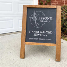 Load image into Gallery viewer, Hand drawn logo for Beyond the Stars on a small stand up easel. Below the crescent moon logo, it says &quot;handcrafted jewelry&quot; and social media information. The chalkboard background is black and all the lettering and illustrations are in white. 
