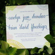 Load image into Gallery viewer, Photo of a multicolored card with cursive design text and mandala patterns on the edges. Wedding invitation with leaves in the background
