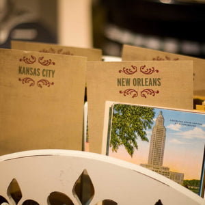 Zoomed view of cards with text "Kansas City" and "New Orleans" on it and photo of building below