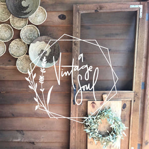A Vintage Soul's hand lettered and hand drawn logo in white on top of a photo of a screen door and wall of hanging circle bacskets.