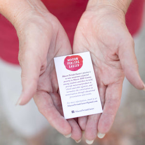 Woman's hands holding a card with macon periods easier logo and information