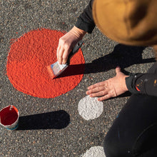 Load image into Gallery viewer, Aerial shot of person painting a red circle on the road.
