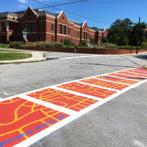Middle ground photo of horizontal part of crosswalk with red and orange street map design.