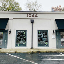 Load image into Gallery viewer, Two glass windows separated by a pole on a building. The windows have green diamond shapes and dots; the left window has &quot;Sparks Yoga&quot; painted in white, and the right window has &quot;what sparks your soul?&quot; painted in white paint.
