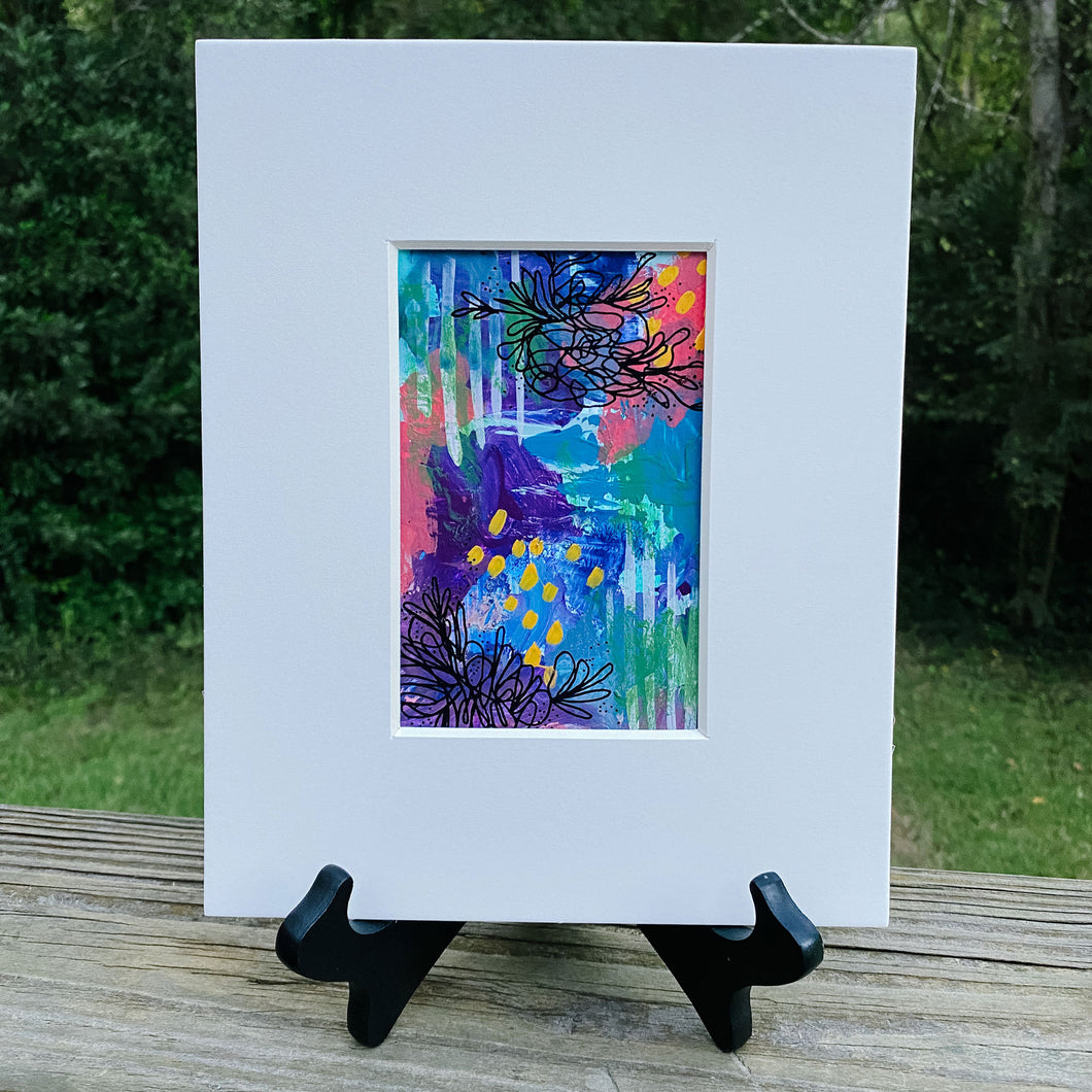 Printed multicolored abstract design inside white print frame.