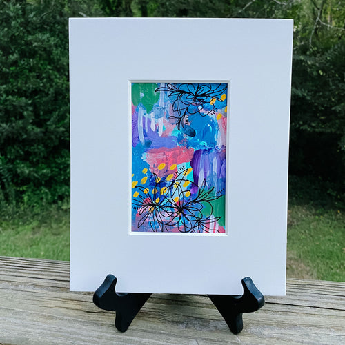 Printed multicolored abstract design inside white print frame.