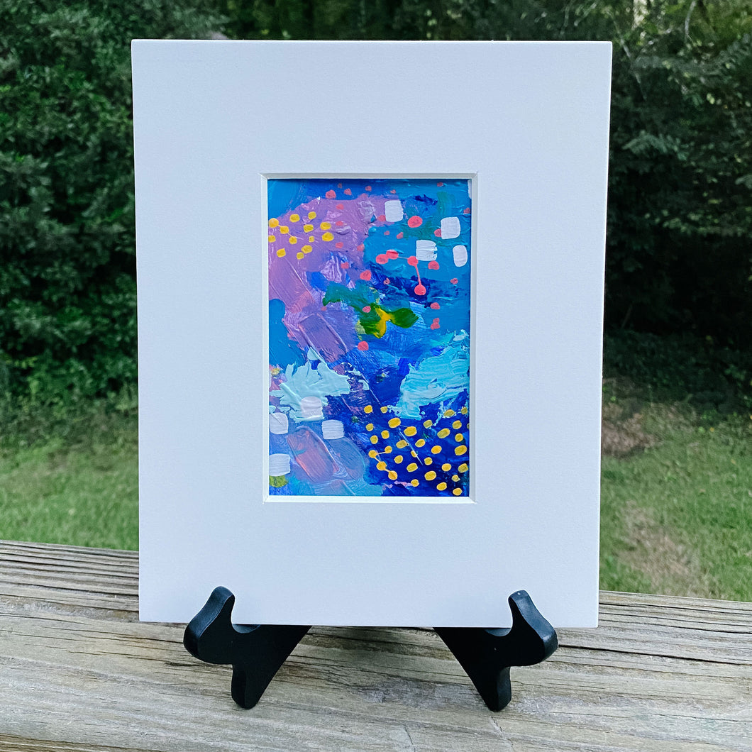 Printed multicolored abstract design inside white print frame.