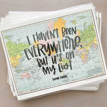 Load image into Gallery viewer, Stack of horizontal multicolored vintage style maps of the world with hand lettered text that says &quot;I haven&#39;t been everywhere, but it&#39;s on my list&quot; in black lettering
