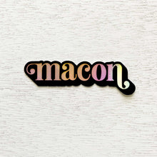 Load image into Gallery viewer, Black bordered, holographic &quot;macon&quot; sticker on white wooden background.

