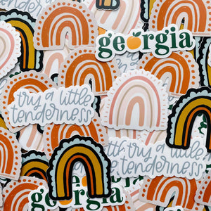 Collage of stickers with multicolored rainbow designs and text including "georgia" and "try a little tenderness"
