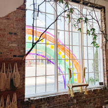 Load image into Gallery viewer, Indoor view of 6x9 window with panes with a rope swing and soft greenery in the foreground. The window has a rainbow painted with lines and shapes and rainbow colors.
